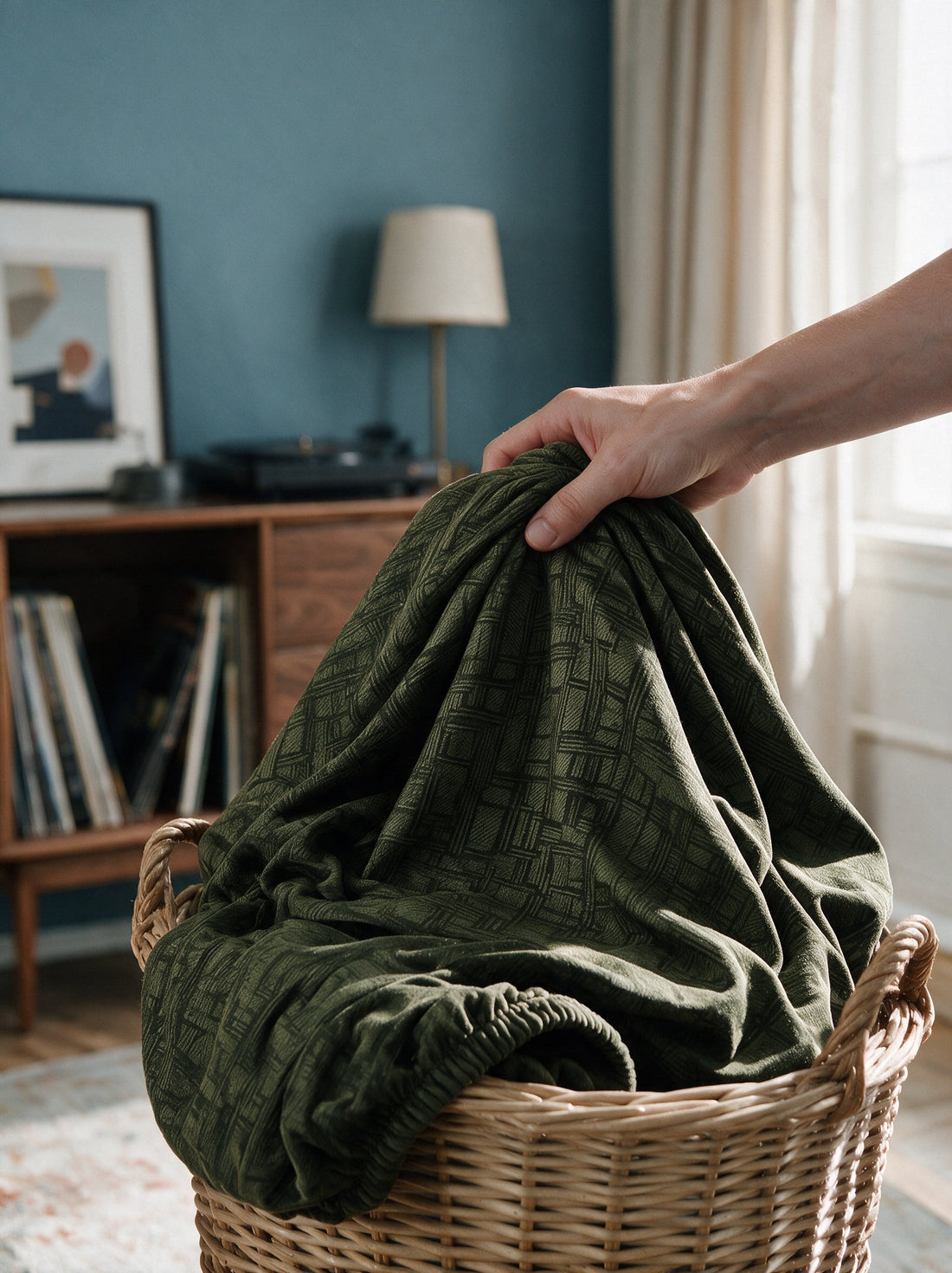The removable Linear Geometric - Olive Green cover gathered in a laundry basket