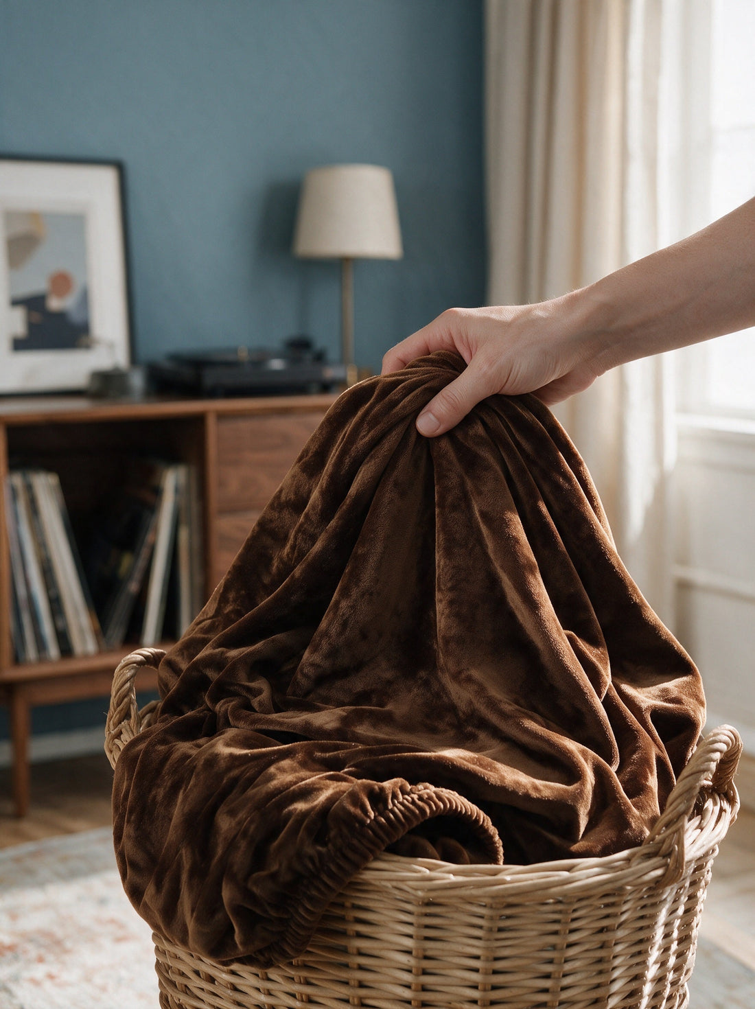 Brown Velvet couch cover gathered in a wicker laundry basket