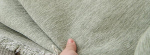 Elligate Sage Green: hand lifting the fringed hem, original product photograph.