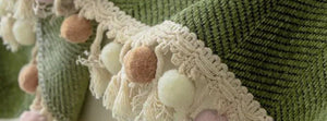 Real Herpome Olive Green throw with its pom-pom and tassel border.